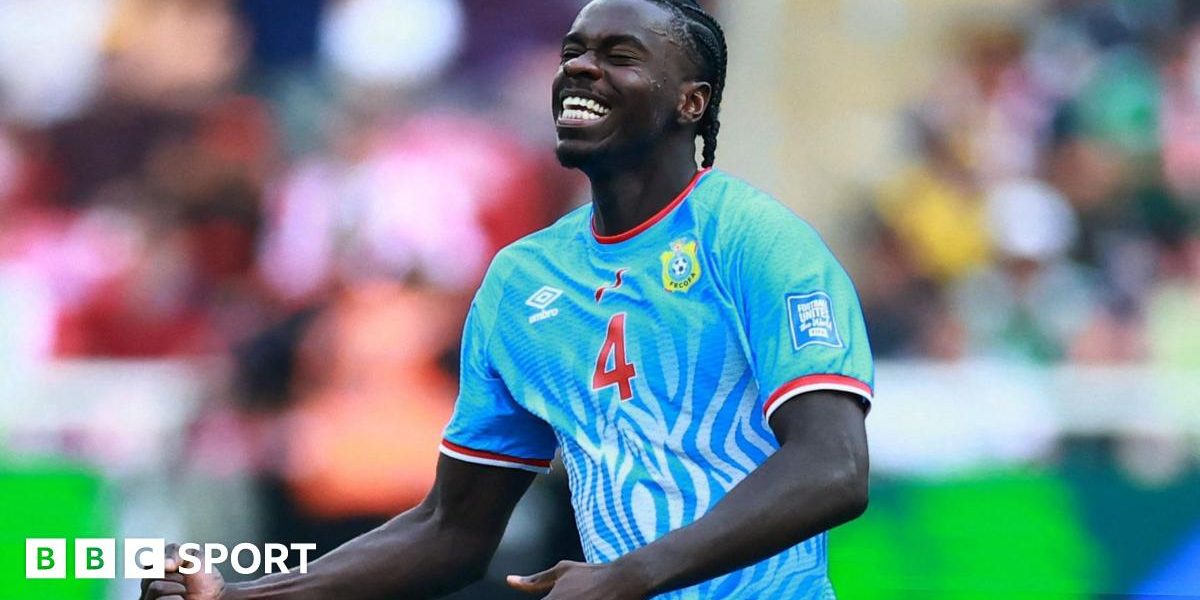 DR Congo defender Axel Tuanzebe celebrates a goal for his country against Jamaica in their World Cup play-off win. He is seen from waist up clenching his right fist at waist level while tilting his head up slightly, with eyes closed and a look of delight on his face