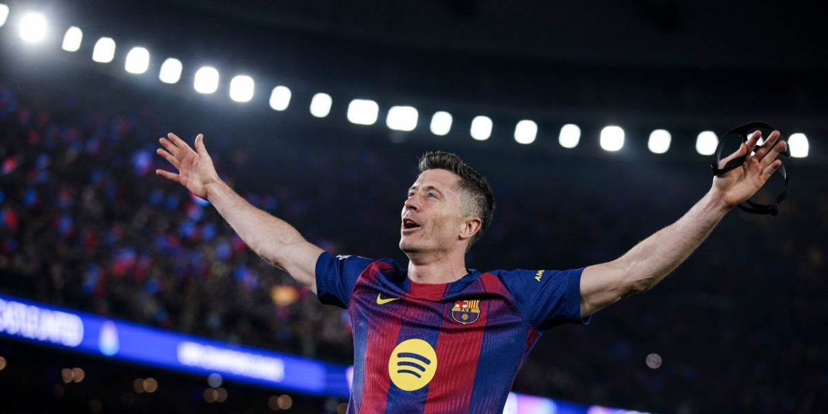 Dwóch piłkarzy w sportowych strojach z opuszczonymi głowami, jeden trzyma dłoń przy twarzy, drugi ma ręce na biodrach. Ich wyraz twarzy i postawa sugerują rozczarowanie bądź smutek po wydarzeniach na boisku.