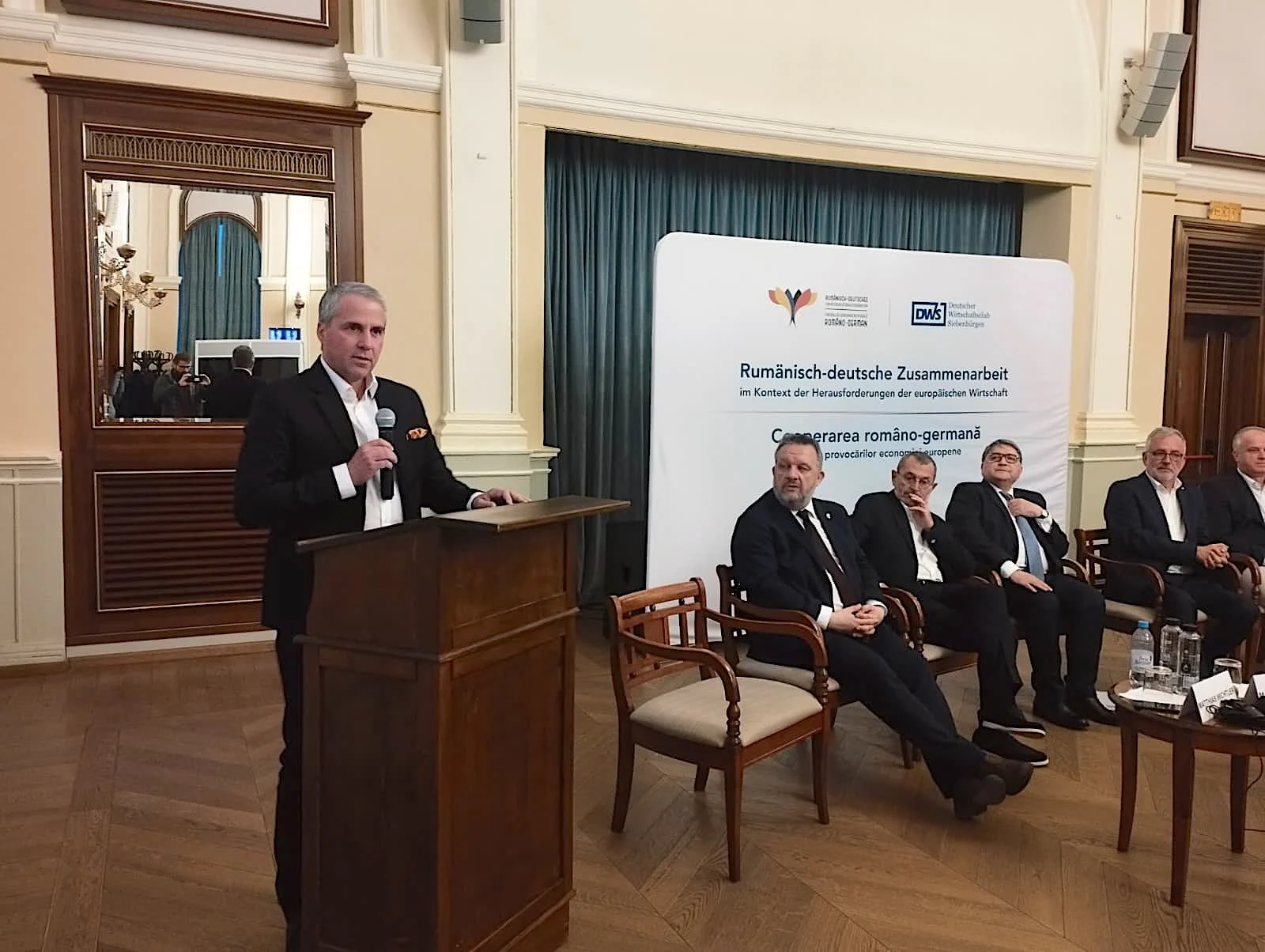 Directorii a două dintre cele mai importante companii germane care investesc în Transilvania au criticat miercuri seară, în Sibiu, instabilitatea economică, deciziile politice și reglementările europene, precum și birocrația care încetinește transporturile